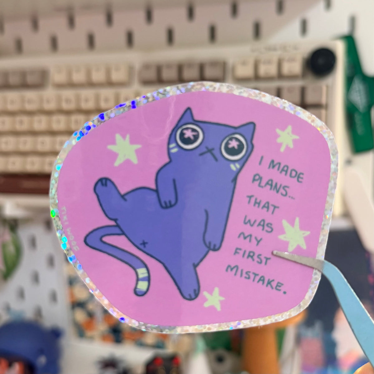 First Mistake Glitter Sticker featuring purple cat with a humorous plans quote on a pink starry background.