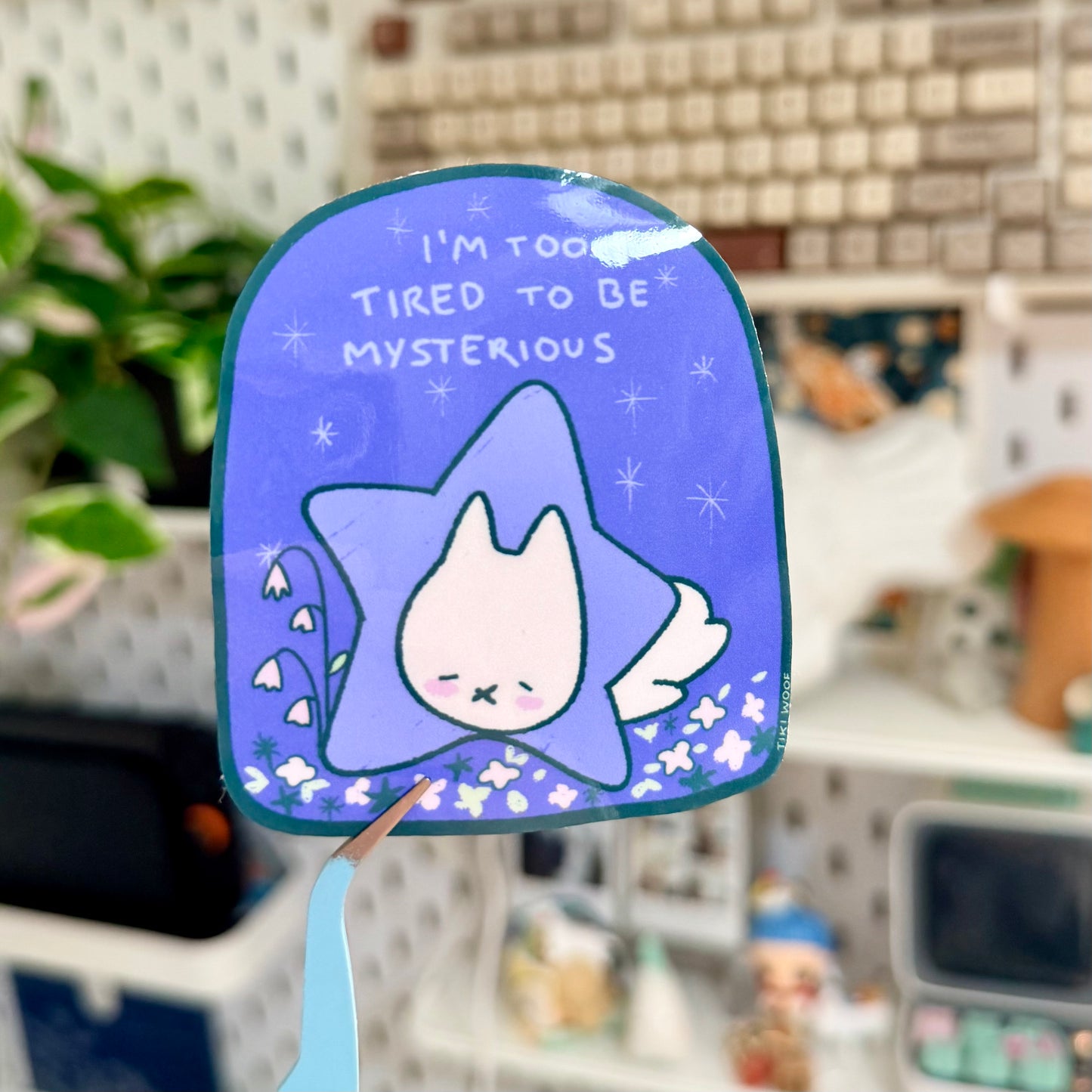 Blue star-shaped mirror with a cartoon cat design and text in a room setting.