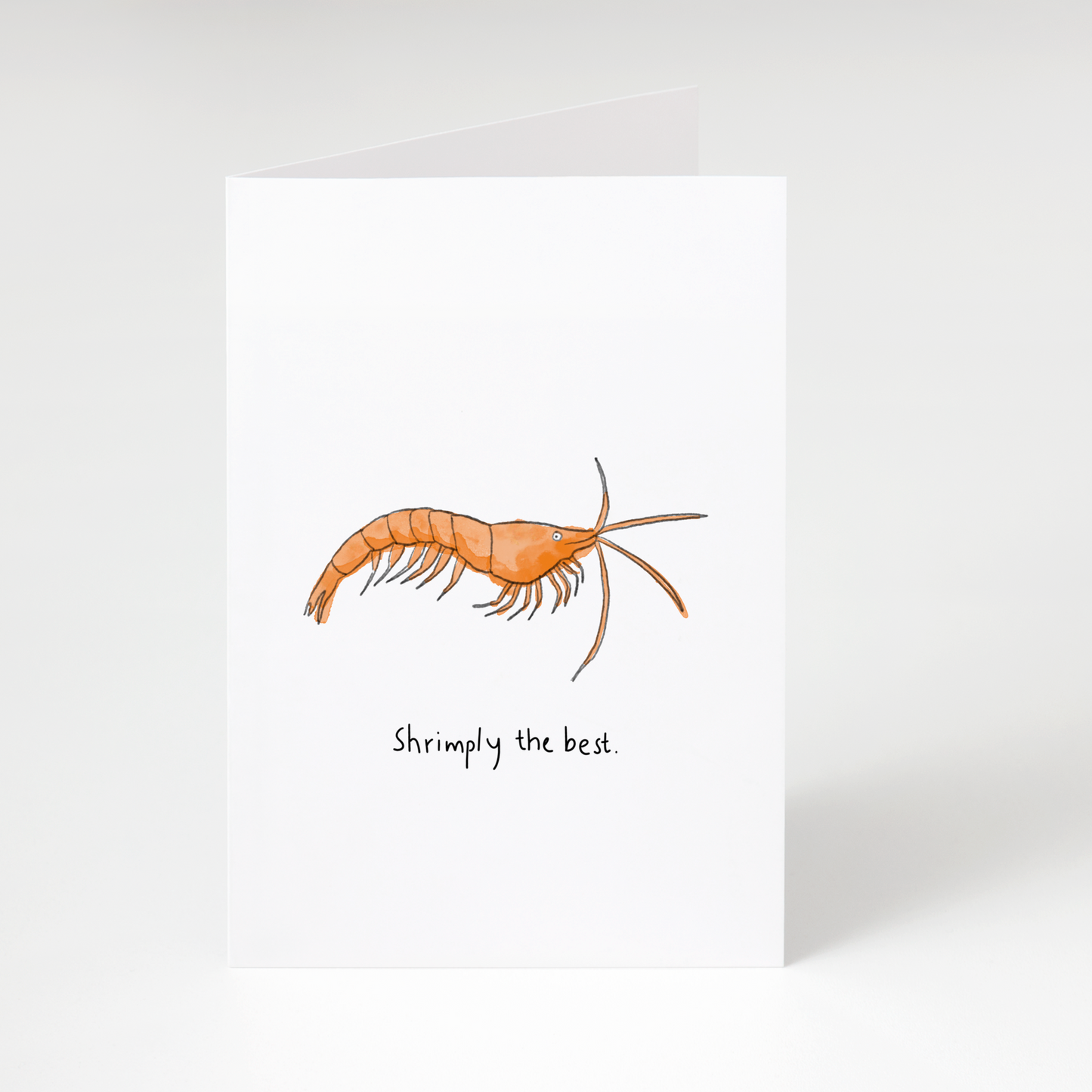 Illustrated orange shrimp with text “Shrimply the best” on white greeting card
