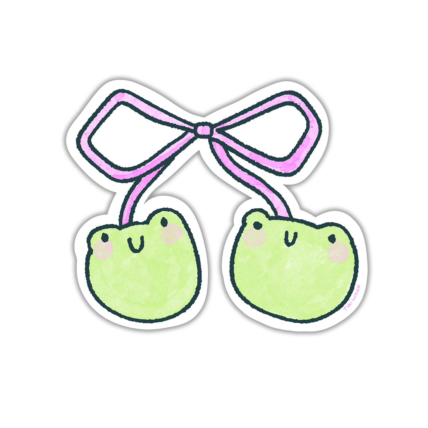 Hand holding a cute vinyl sticker of two pastel green frog faces tied together with a pink bow, illustrated in a kawaii Tiki Woof Studio style.