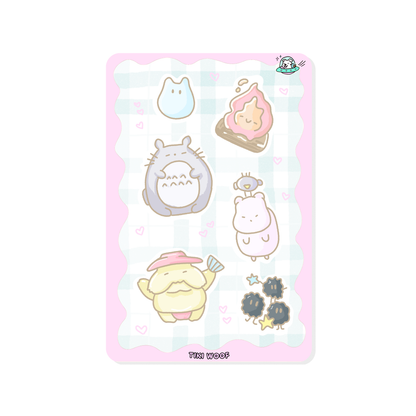 Mini sticker sheet featuring pastel Studio Ghibli inspired characters including Totoro, soot sprites, and other cute creatures on a soft pink checkered background.```