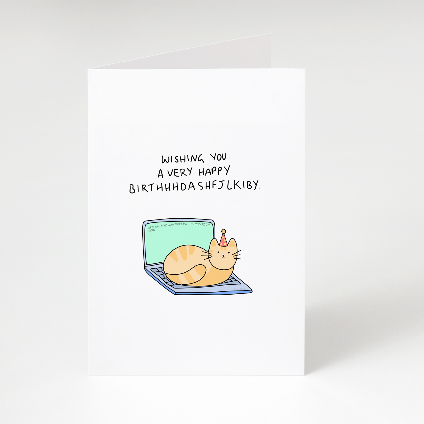 Cute cat wearing party hat sitting on laptop with text “Wishing you a very happy birthhhdashfjlky” on white birthday greeting card