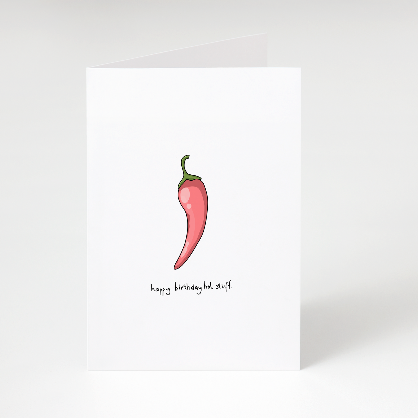 Red chilli pepper illustration with text “happy birthday hot stuff” on white funny birthday greeting card
