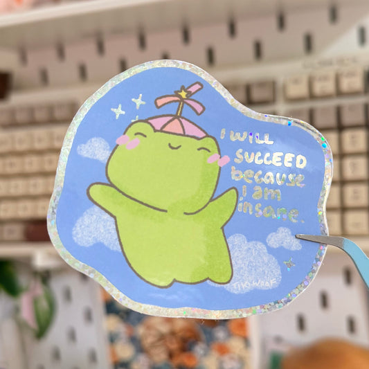 I Will Succeed Because I Am Insane Glitter Sticker featuring green character against a blue cloudy sky with a success quote.