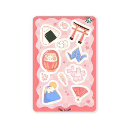 Mini sticker sheet featuring Japanese inspired illustrations including Mt. Fuji, cherry blossoms, origami crane, torii gate, onigiri, and daruma doll on a pink checkered background.```