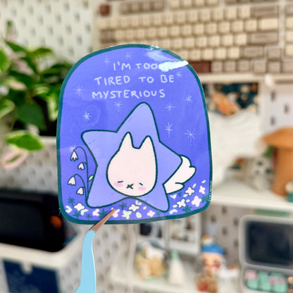 Blue star-shaped mirror with a cartoon cat design and text in a room setting.