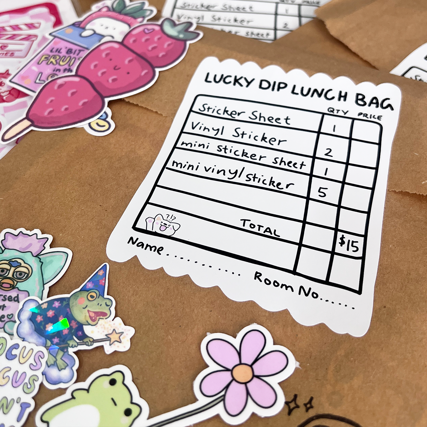 Lucky Dip Lunch Bag with Tiki Woof stickers displayed, including frog minis, vinyl stickers and a sticker sheet beside labelled paper bags.
