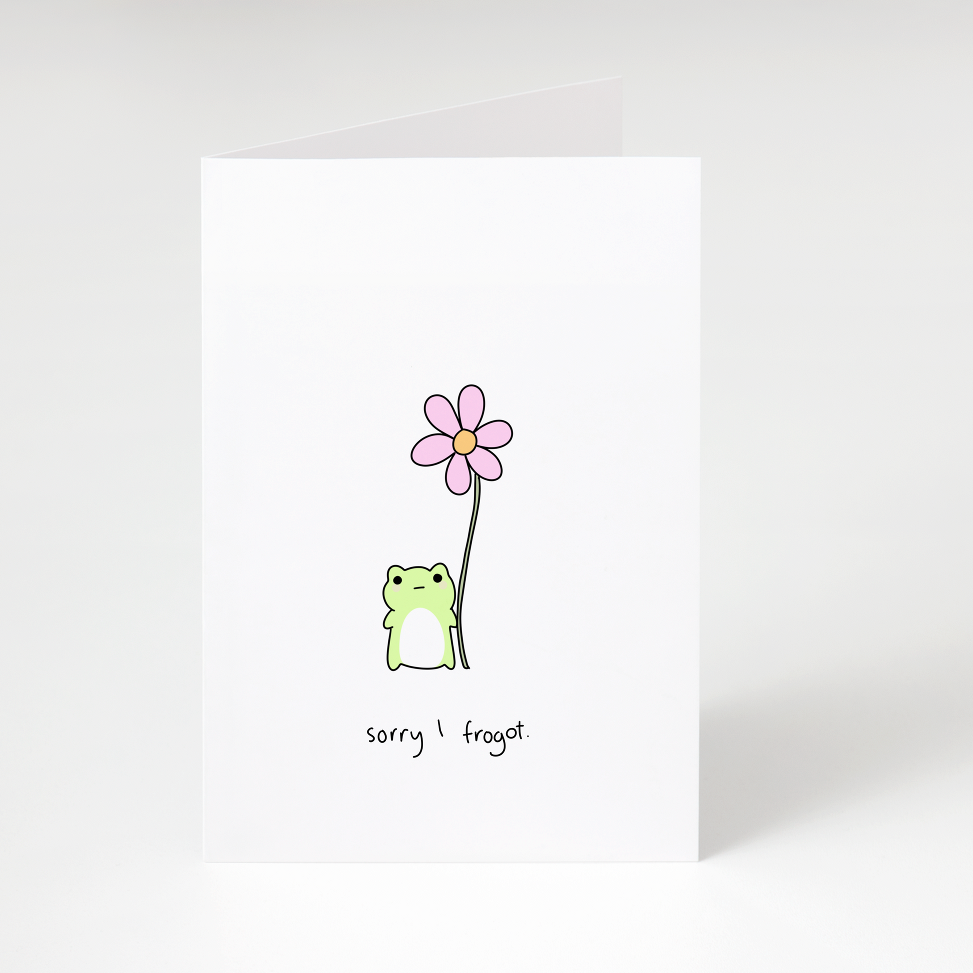 Cute green frog holding pink flower with text “sorry I frogot” on white greeting card